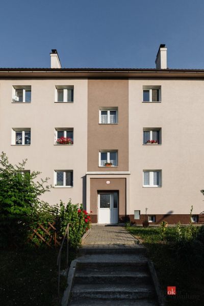 Apartment building in Zvolen on M. Bazovského Street with a colorful facade and a garden.