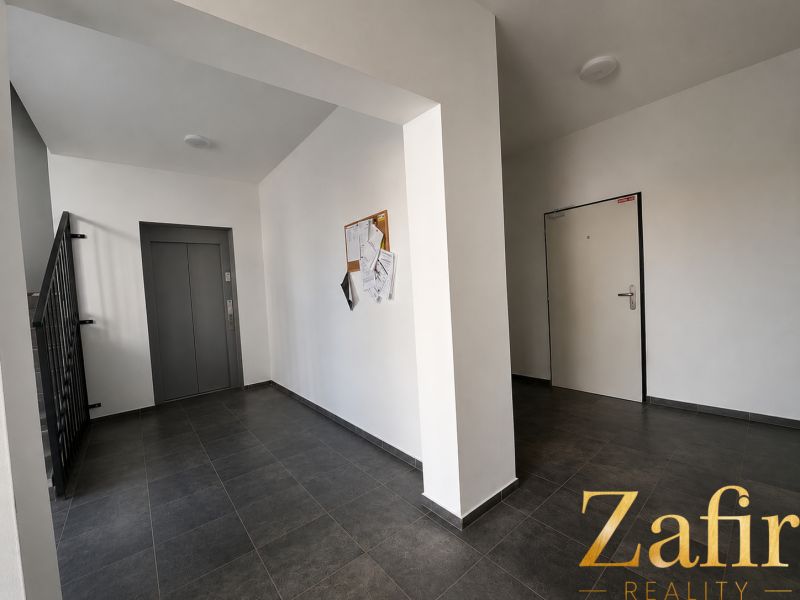 Common areas with an elevator and staircase in a building with a one-room apartment.