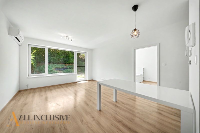 Interior of a 2-room apartment with a wooden decor floor and a large window.