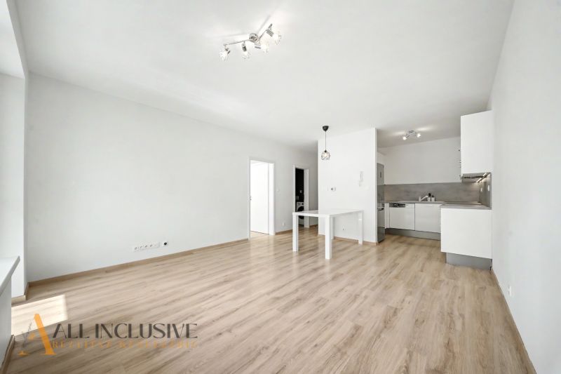 Living room in a 2-room apartment with a kitchen and a wooden decor floor.