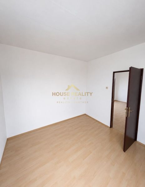 A room with a wooden floor decor and white walls in a 3-room apartment.