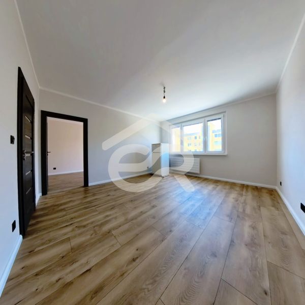 Living room in a three-room apartment with a wooden decor floor.