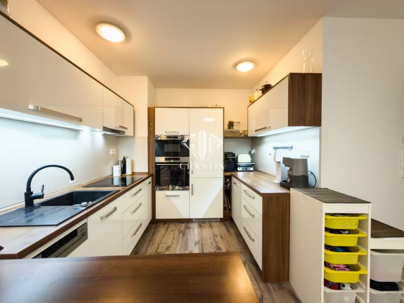 A kitchen in a 3-room apartment with a wooden decor and modern appliances.