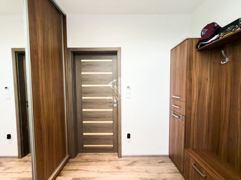 Entrance hall in a 3-room apartment with wooden decor furniture and storage space.