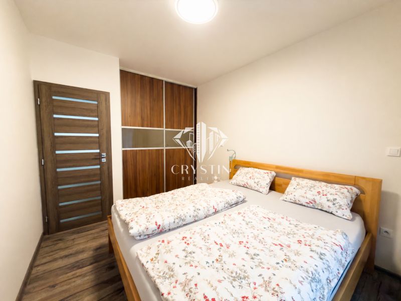 A bedroom in a 3-room apartment with a double bed and a built-in wardrobe.