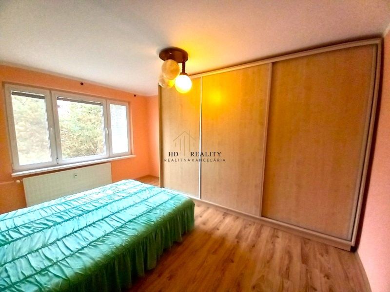 Bedroom with a built-in wardrobe and a floor with a wood decor in a 4-room apartment.