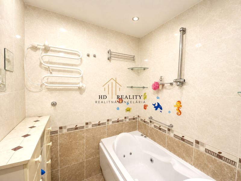 Bathroom in a 4-room apartment with a bathtub and ceramic tiles on the walls.