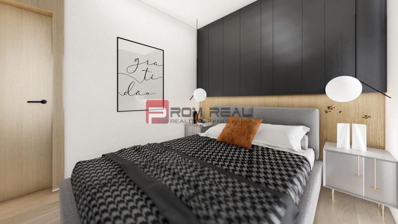 A bedroom in a two-room apartment with a wood-patterned floor, elegant furniture, and decorations.