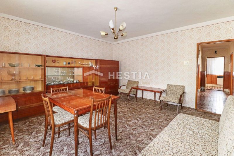 The interior of a family house with 20th-century furniture and a patterned carpet.