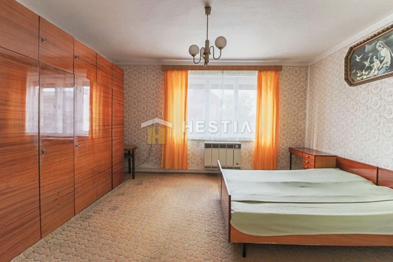 How does the interior of a bedroom with wallpaper, wardrobes, and a bed in a family house look?