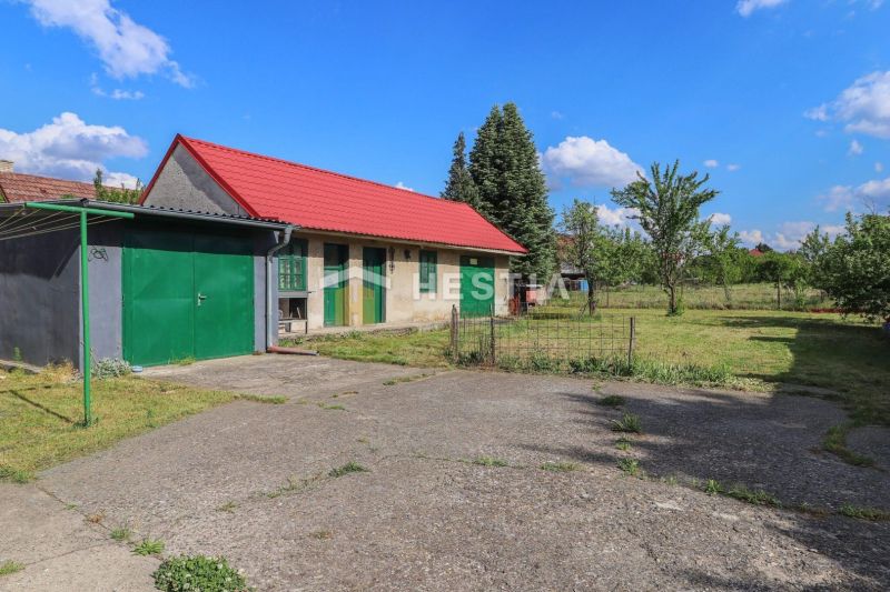 A family house in Borský Mikuláš with a grassy garden and a red roof.