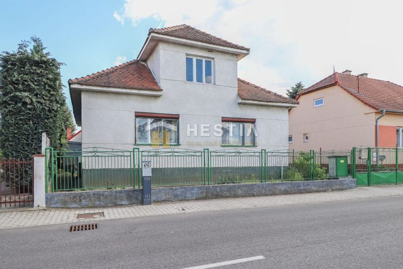 A family house in Borský Mikuláš with a red tile roof and a green fence.