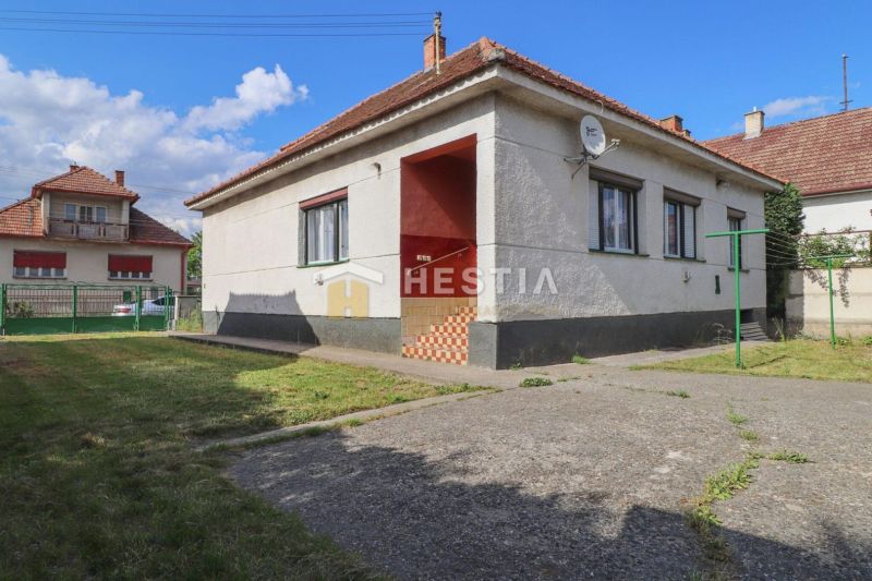 A family house in Borský Mikuláš with a landscaped lawn, paved area, and satellite dish.