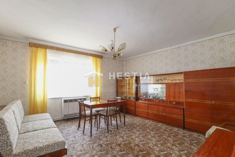 Living room in a family house with wooden furniture and a patterned carpet.
