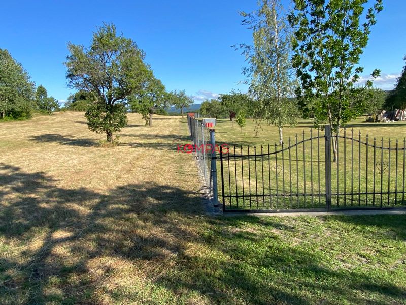 Agricultural and forest lands in Krupina are fenced with tree planting on a grassy area.