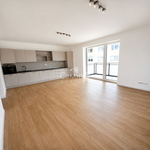 Spacious kitchen with wood-patterned flooring in a 2-room apartment.