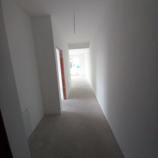 A hallway in a 2-room apartment with a bright interior and an empty floor without decor.