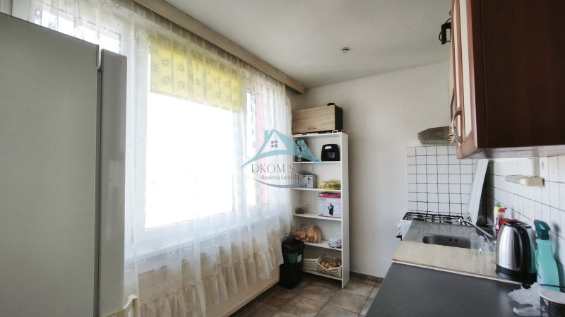 A kitchen in a 2-room apartment with a window, a simple kitchenette, and practical storage spaces.