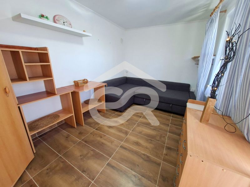 Living room with a corner sofa, wooden furniture, and a floor with a wood decor.