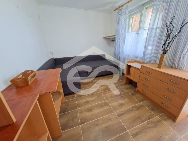 A room in a family house with a gray sofa, wooden furniture, and a floor with a wooden decor.