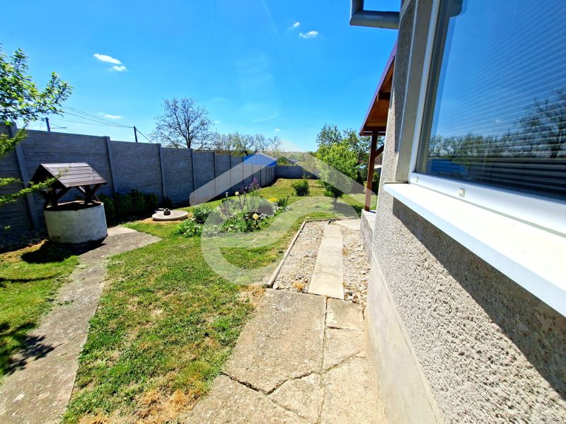 A garden at a family house in Jasová with a lawn and a well.