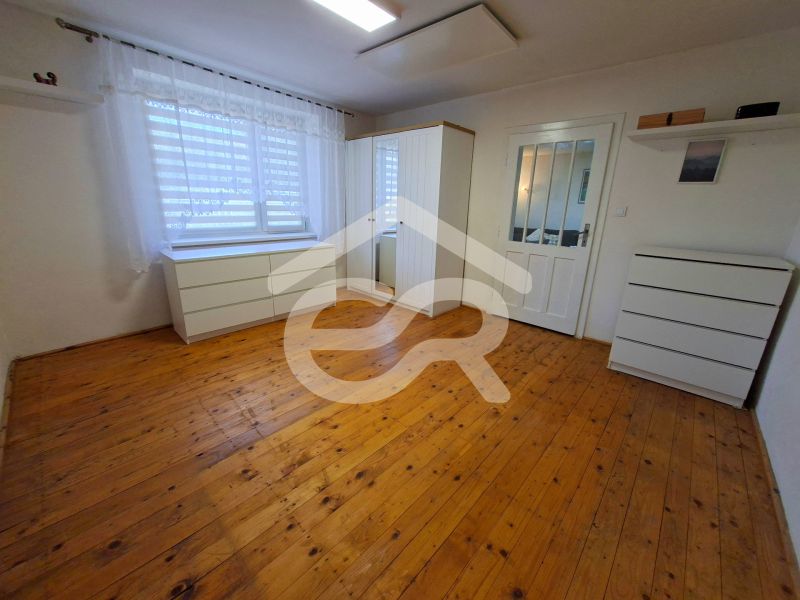 A room in a family house with white furniture and a wooden decor floor.
