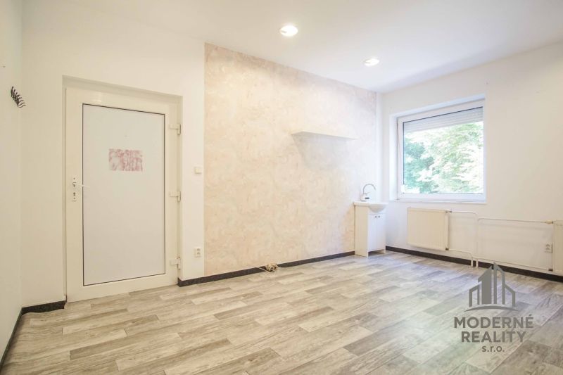 Interior of offices with wood-patterned flooring, a sink, and a window.