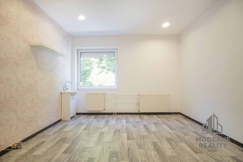 Offices with a pastel wall, a sink, and a wood-patterned floor.