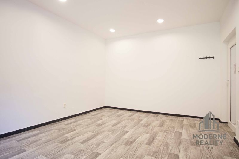 An empty office interior with wood-patterned flooring and white walls.