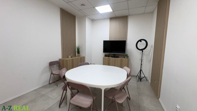 Business premises with a conference table, folding chairs, and a television on the wall.