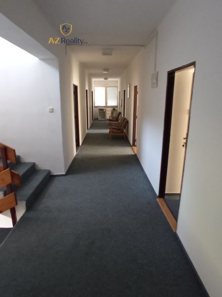 A corridor in hotels and guesthouses with carpet and wooden details on the stairs.