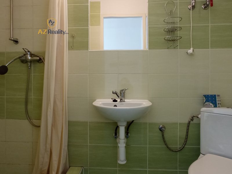 Bathrooms in hotels and guesthouses with a sink, shower, and toilet, light green tiles.