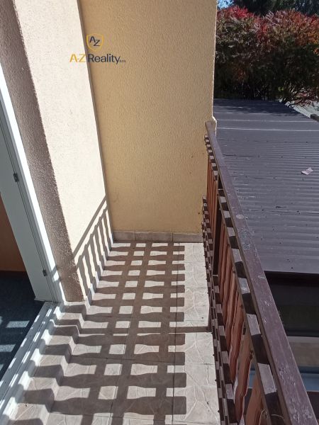 A balcony with tiles and wooden railing in hotels and guesthouses in Patince.