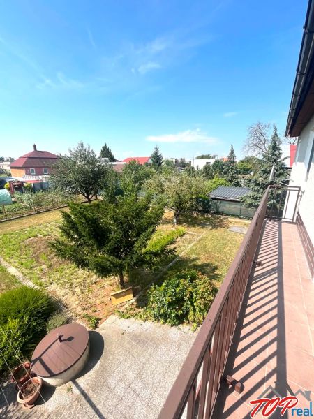 From the balcony of the family house on Agátová Street in Čaňa, you can see a green garden.