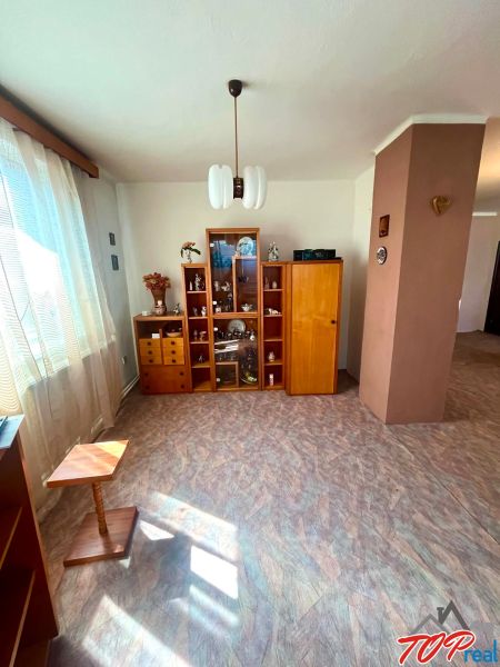 Living area in a family house with a wooden decor floor and a display cabinet.