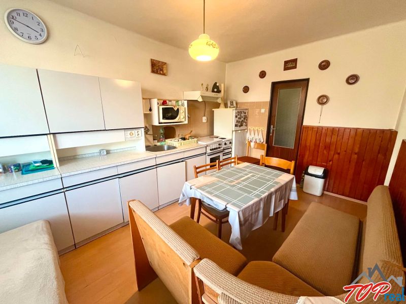 A kitchen in a family house with seating, a kitchen unit, and wall decorations.