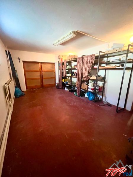 A garage in a family house with a shelving system and wooden doors.
