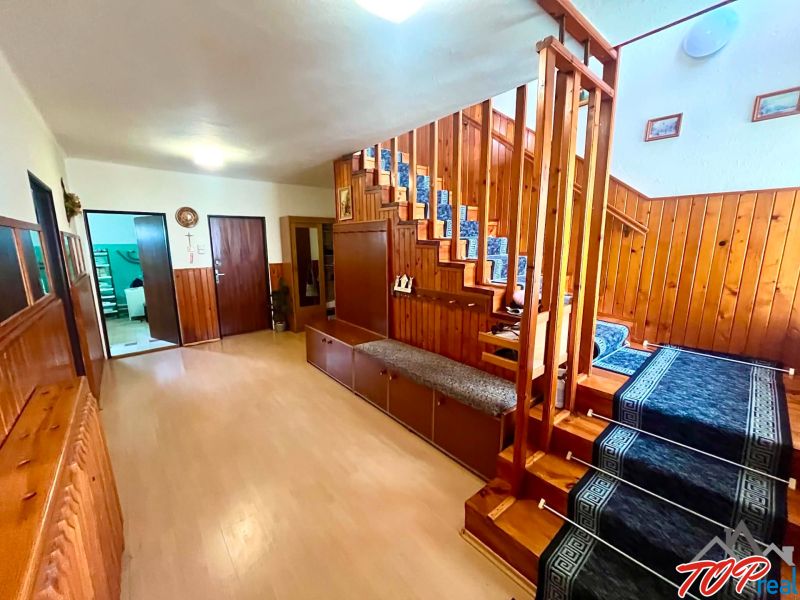 Entrance hall with wooden stairs and a floor with a wooden decor in a family house.