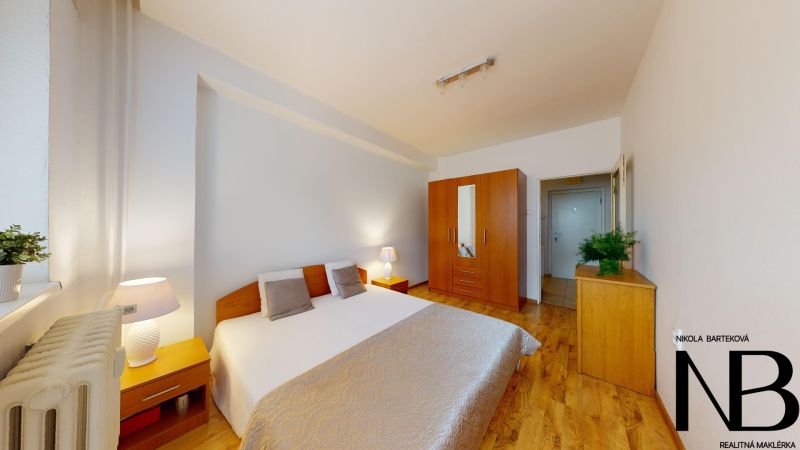 Bedroom with a wardrobe and two bedside tables in a 2-room apartment on K výstavisku street.