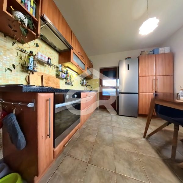 A kitchen in a 4-room apartment with a wooden kitchen unit and modern appliances.