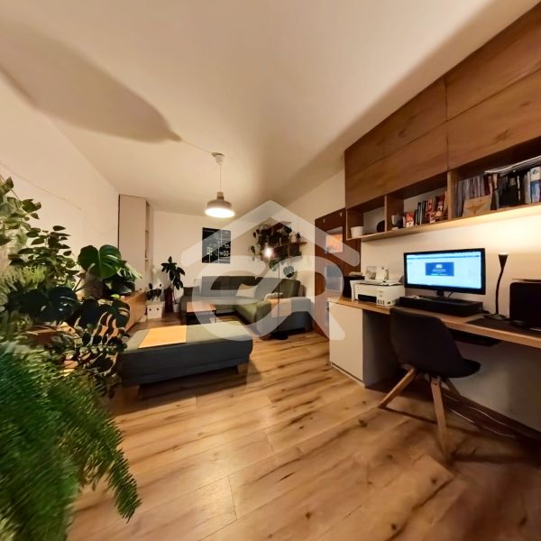 Living room with a home office in a 4-room apartment with a wooden decor floor.