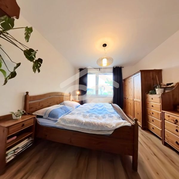 A bedroom in a 4-room apartment with wooden furniture and a wooden decor floor.