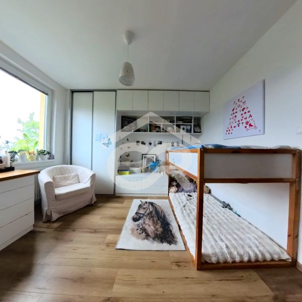 A room in a 4-room apartment with a wooden decor floor, a bed, and wardrobes.
