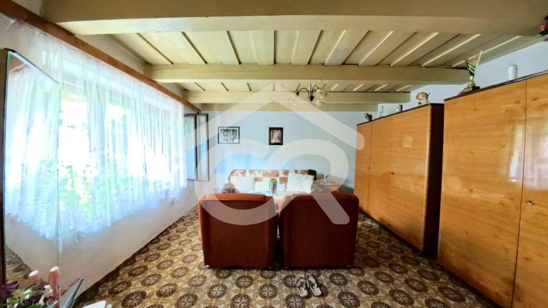 A living room in a family house with brown furniture and a patterned carpet.