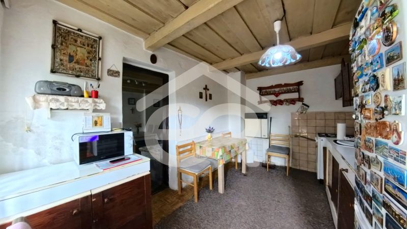 A kitchen in a family house with a wooden ceiling, decorations, and a microwave oven.