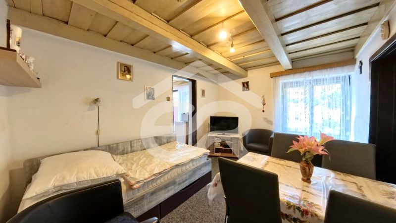 Living room in a family house with a wooden ceiling, seating, and a television.