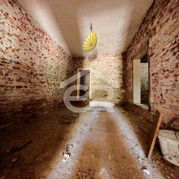 Brick walls and bare floor in the interior of a family house.
