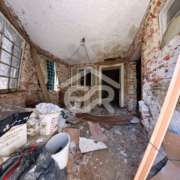The interior of a family house with unplastered brick walls and construction mess.