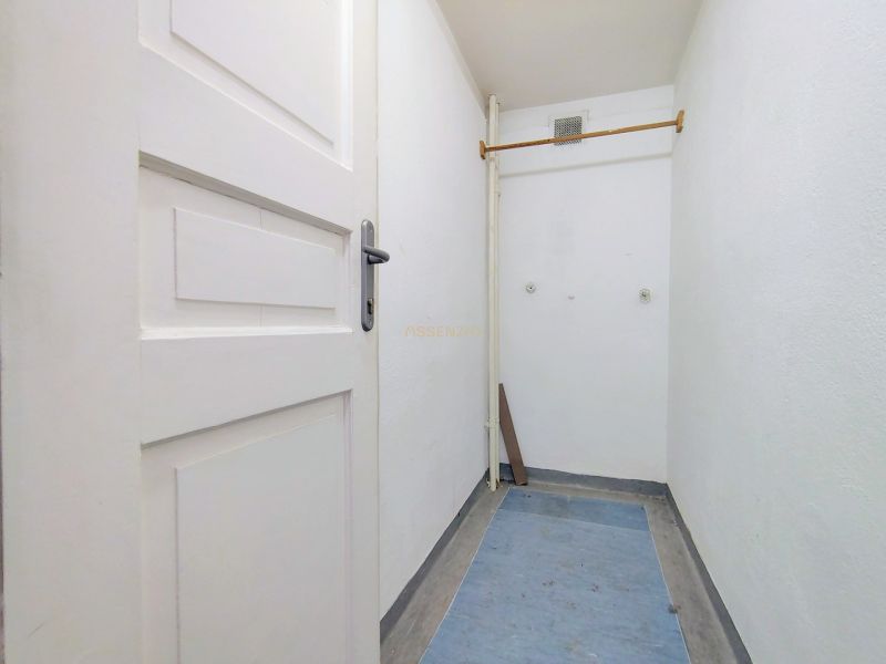 Narrow corridor with wooden doors and a coat rack in the offices.
