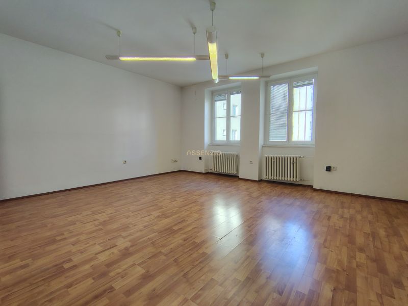 Offices with wood-patterned flooring and windows through which natural light penetrates.